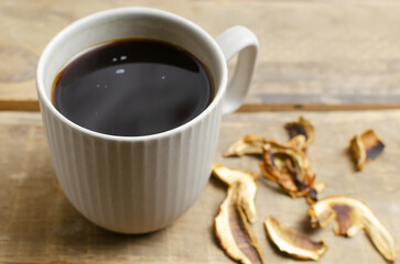 Mushroom coffee in a gray cup on a wooden background. The concept of a trendy beverage. The drink is good for health. Horizontal orientation. Selective focus. Copy space.