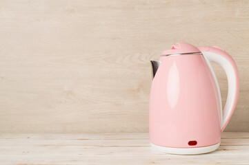 Modern electric pink kettle on wooden table