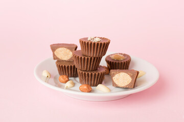 Tasty chocolate peanut butter cups on color background