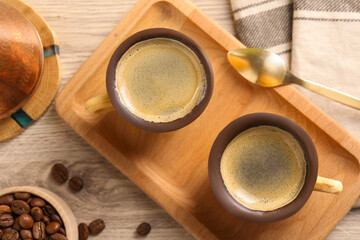 Fototapeta na wymiar Delicious biscuit cups with espresso, spoon and coffee beans on wooden table, flat lay