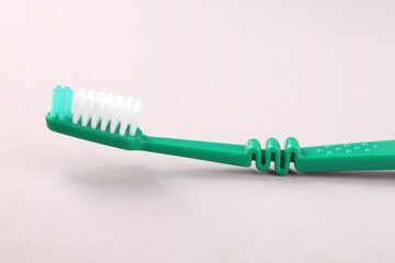 One green toothbrush on light background, closeup