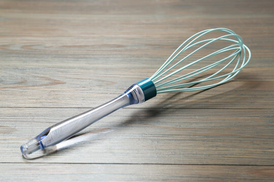 One whisk on wooden table, closeup. Kitchen tool