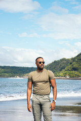 African American man with clothes in the beach