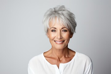 Fototapeta premium Radiant elderly senior model woman with graceful grey hair, portraying joy and positivity through a genuine and warm smile on white