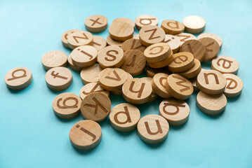 Wooden alphabet over a blue background.