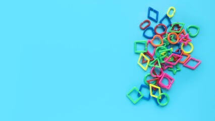 Educational toys, Cognitive skills, kid development. Colorful geometric shapes toys over a blue background.