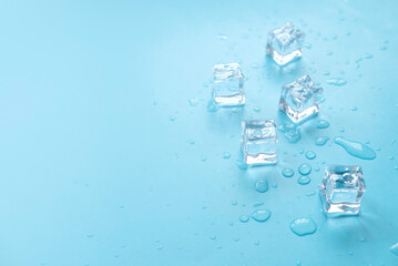 Concept of cold and refreshing. Ice cubes with water drops on a blue background.