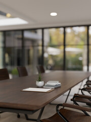 Close-up image of a hardwood meeting table in a modern spacious meeting room. Business workspace