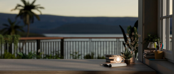 A wooden tabletop with a blurred background of a balcony with coast view. Home workspace