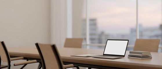 A laptop mockup on a meeting table in a modern meeting room. place of work, corporate job