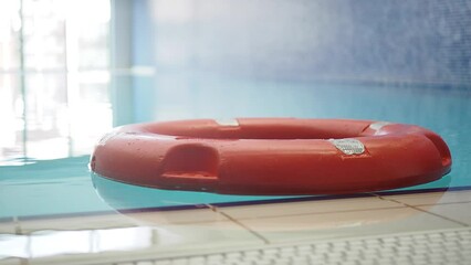 Red life buoy in swimming pool.. Help and support concept.