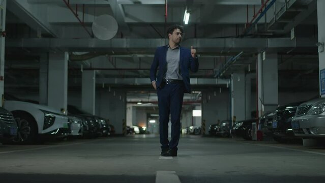 Man approaches a his luxury car in a parking garage realizes that he forgot the keys and leaves annoyed