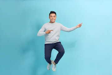 Full length photo of confident pretty man jumping high thumbs up empty space
