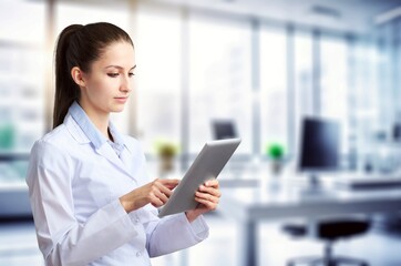 Young female dentist using a modern digital tablet