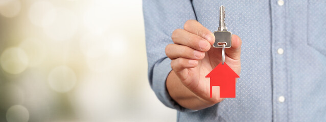 Real estate agent handing over  house keys in hand