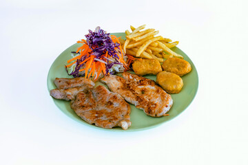 Steak pork chop with nugget, french fries and vegetable salad on dish with white background. Meat steak and french fries serving plate fast food meal. Steak meal set. Grilled meat with trimmings.
