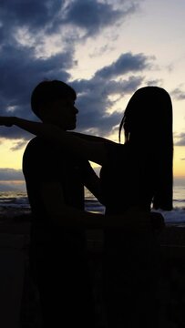 Siluetas de j&oacute;venes irreconocibles dando un abrazo cerca de la playa en Puerto Vallarta