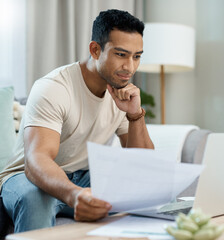 Home, bills and man on laptop thinking of finance, reading website and taxes or asset management on sofa. Young person with documents for mortgage, budget solution and insurance choice on computer