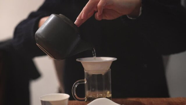 person pour a cup of tea