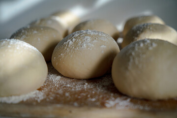 close ups of homemade pizza and pretzel dough on a cutting board with flour 