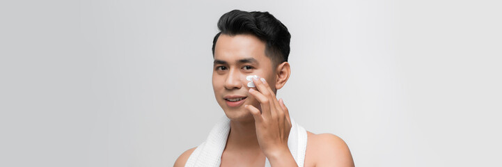 Young man with moisturizer on the face