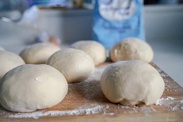 close ups of homemade pizza and pretzel dough on a cutting board with flour 
