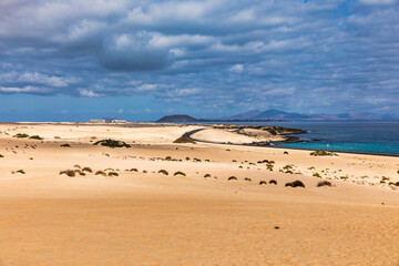 Sand dunes, Las Dunas de Corralejo, Corralejo Natural Park, dramatic cloud formation, Fuerteventura, Canary Islands, Spain. Sand dunes landscape, Corralejo, Fuerteventura, Canary Islands, Spain.