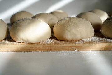 close ups of homemade pizza and pretzel dough on a cutting board with flour 