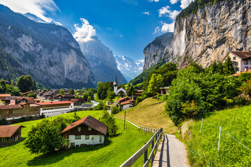 Lauterbrunnen valley with famous church and Staubbach waterfall. Lauterbrunnen village, Berner Oberland, Switzerland, Europe. Spectacular view of Lauterbrunnen valley in a sunny day, Switzerland.