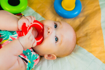 Portrait of a cute baby girl playing with colorful toys at home