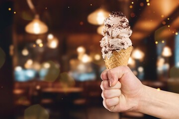 Hand holding tasty sweet ice-cream in restaurant