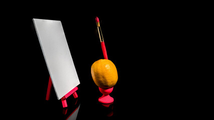 Composition with lemon and empty canvas on a black background