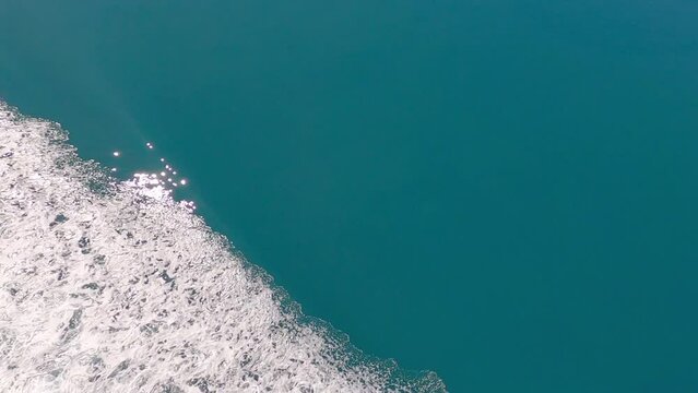 Sunshine sparkles onto beautiful turquoise-colored sea beside boat's wake - Tory Channel, South Island (Cook Strait crossing, New Zealand)