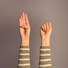 Hands raised displaying the 'Signal for Help', a covert SOS used to silently communicate distress...