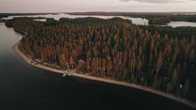 Aerial, Drone, Finnish summer hut in forest at a lake, Sunset