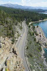 Obraz premium Vertical view of Highway 50 from the top of Cave Rock on the East Shore of Lake Tahoe on a sunny day with blue skies 