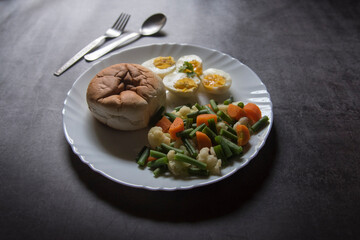 Healthy breakfast food bread, eggs and boiled vegetables on a plate. Close up, selective focus.