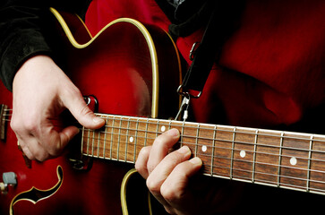 Hands of a guitarist playing an electric guitar. Close-up.