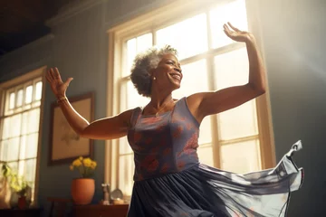 Poster Smiling afro american elderly woman dancing near the window © Slepitssskaya