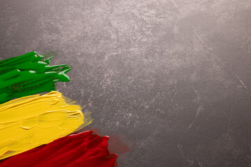 Green, yellow and red paints with copy space on grey stone background