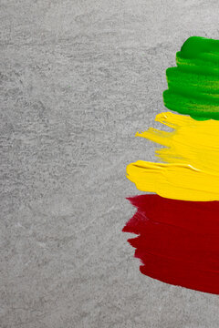 Vertical image of green, yellow and red paints with copy space on grey stone background