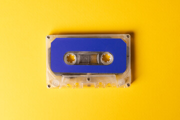 Overhead view of blue cassette tape on yellow background