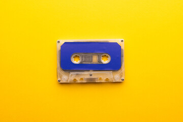 Overhead view of blue cassette tape on yellow background