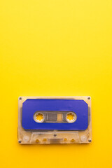 Overhead view of blue cassette tape with copy space on yellow background