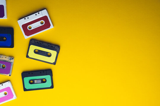 Overhead view of colourful cassette tapes with copy space on yellow background
