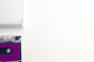 Overhead view of purple cassette tape and white box with copy space arranged on white background
