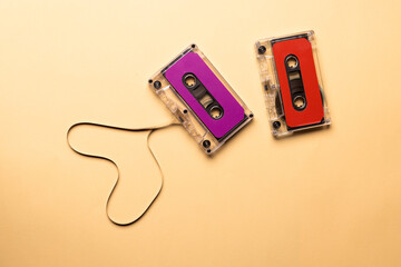 Overhead view of two colourful cassette tapes on beige background