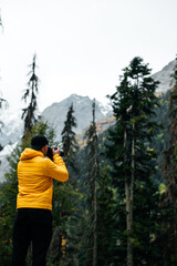Fototapeta na wymiar photographer takes pictures of landscapes in a mountain forest