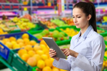 professional nutrition doctor with fresh fruits and digital tablet.