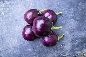 Fresh eggplant on a black concrete floor top view. Agricultural concept, cultivated vegetables